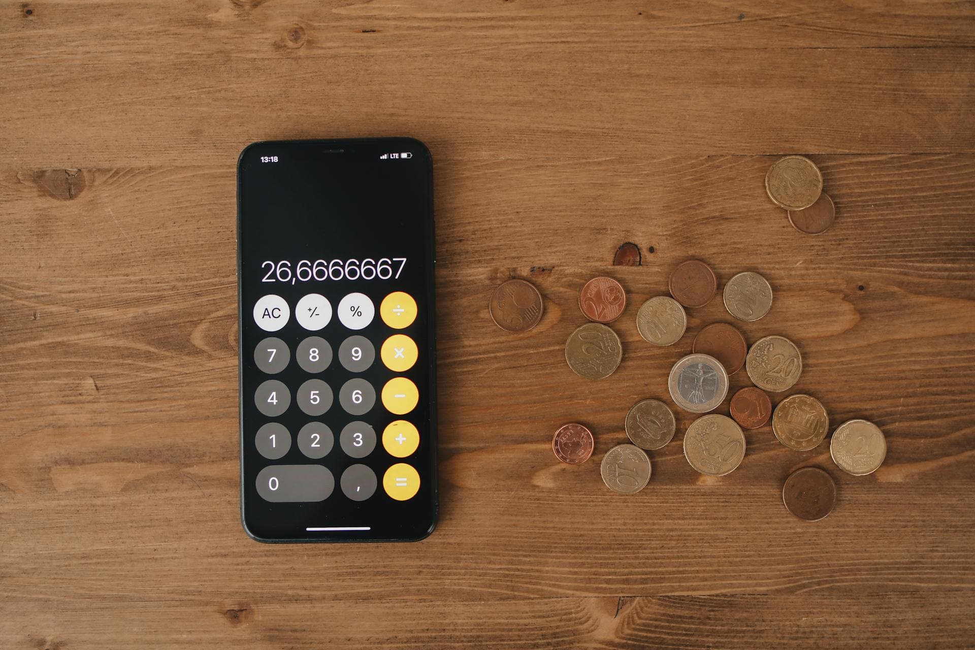 Taschenrechner, Münzen und Finanzdokumente auf einem Schreibtisch — Symbol für Solar-Finanzierung