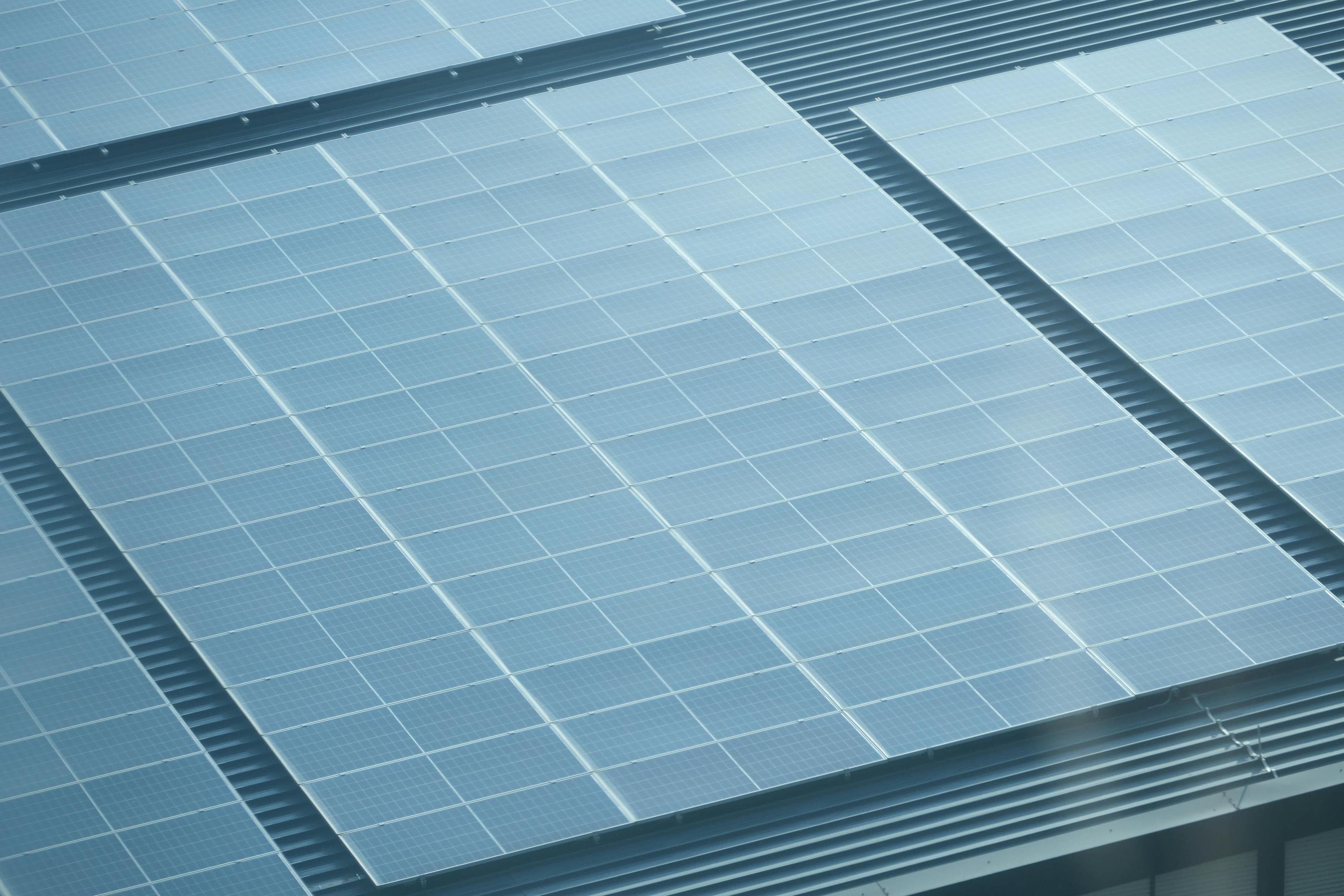 Vogelperspektive auf ein Hausdach mit großflächiger Photovoltaikanlage und vielen Modulen
